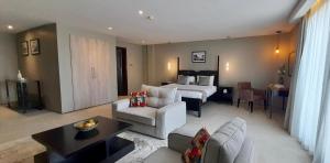 カンパラにあるMeilin International Hotelのベッドとリビングルームがあるホテルの部屋