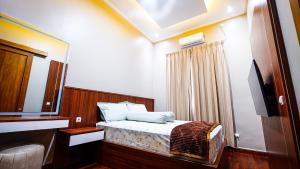 Dormitorio pequeño con cama y espejo en Omah Tamansiswa, en Timuran
