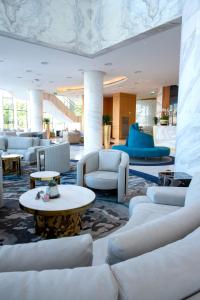 a lobby with white couches and tables at Century Marina Hotel - Lusail in Lusail
