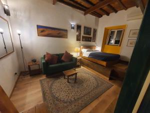 a living room with a bed and a green couch at Appartamenti Gardenia in Rome