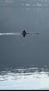 a person is rowing a boat on the water at Villa Giardino con pontile sul Lago D’Orta in riva in Orta San Giulio