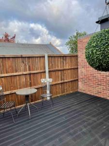 d'une terrasse avec une table, des chaises et une clôture. dans l'établissement Boutique Annexe Close To Norwich City & Airport, à Horsham St Faith