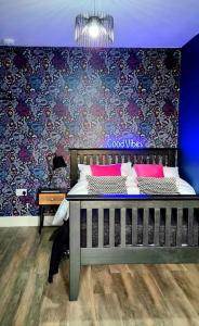 Schlafzimmer mit einem Bett mit blauer Wand in der Unterkunft Boutique Annexe Close To Norwich City & Airport in Horsham St Faith