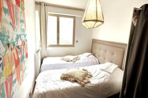 twee bedden in een kleine kamer met een raam bij Le Touquet Beach, Front de Mer in Le Touquet-Paris-Plage