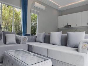 un salon avec un canapé et une table dans l'établissement Aranya pool villa, à Ban Phu Yai