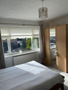 a bedroom with a bed and a large window at Cumberland Avenue prenton Wirral 3bed detached house with a lovely view looking out on to a field from the rear close to all amenities in Birkenhead