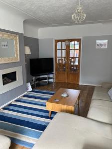 a living room with a couch and a table at Cumberland Avenue prenton Wirral 3bed detached house with a lovely view looking out on to a field from the rear close to all amenities in Birkenhead