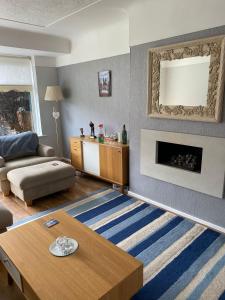 a living room with a couch and a fireplace at Cumberland Avenue prenton Wirral 3bed detached house with a lovely view looking out on to a field from the rear close to all amenities in Birkenhead