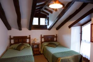 Ліжко або ліжка в номері Casas Rurales y Apartamentos La Hornera