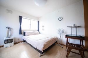 a bedroom with a bed and a desk and a window at Sumiyoshi House Room B in Otaru
