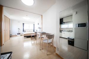 a kitchen and living room with a table and chairs at Sumiyoshi House Room B in Otaru