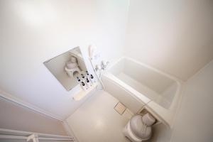 a white bathroom with a sink and a toilet at Sumiyoshi House Room B in Otaru