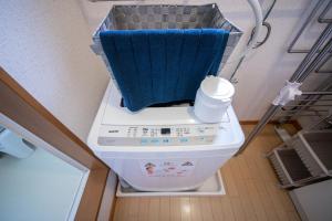 a washing machine with a blue towel on top of it at Sumiyoshi House Room B in Otaru
