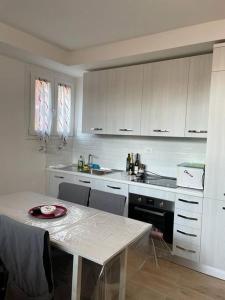a white kitchen with a table and a counter top at Casa di Mattia in Villanova