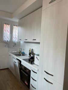 a kitchen with white cabinets and a sink at Casa di Mattia in Villanova