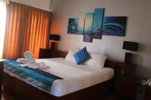 a bedroom with a bed with a stuffed animal on it at Mount Marina Villas in Galle