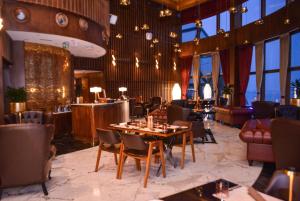 a restaurant with tables and chairs in a room with windows at Century Marina Hotel - Lusail in Lusail +41 photos