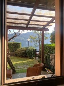 Blick aus einem Fenster auf eine Terrasse mit Aussicht in der Unterkunft Villa Giardino con pontile sul Lago D’Orta in riva in Orta San Giulio