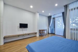 a bedroom with a bed and a flat screen tv at The Garden Capsule Hotel in Danang