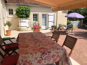 a table with a floral table cloth on a patio at La Petite Jucherie in Saint-Hippolyte