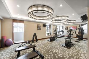 The LA Hotel 新世界伟瑞酒店 في شنجن: صالة ألعاب رياضية مع العديد من معدات التمرين في الغرفة