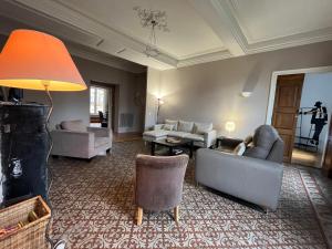 een woonkamer met banken en stoelen en een lamp bij Terrasse de la canourgue - Premiere conciergerie in Montpellier