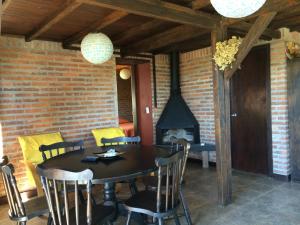 comedor con mesa, sillas y chimenea en Buenavis'TA en Punta del Diablo