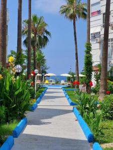 a pathway with palm trees and blue barriers at Royal Ruth in Alanya