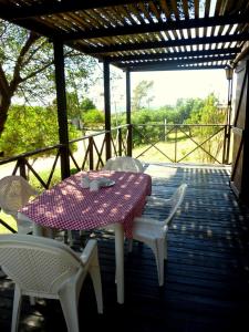una mesa y sillas en un porche cerrado con mesa y sillas en Buenavis'TA, en Punta del Diablo