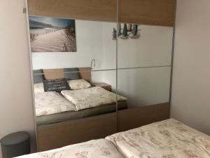 1 Schlafzimmer mit 2 Betten und einem Spiegelschrank in der Unterkunft Lindenpalais Wohnung 24 in Heiligendamm