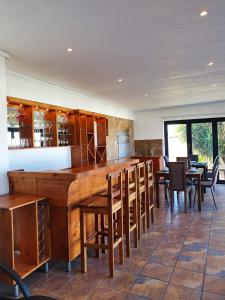 a kitchen with a bar with wooden tables and chairs at La Grace Executive Guesthouse in Amsterdamhoek