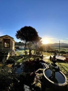 a fountain in a yard with the sunset in the background at O Balcon Do Oitaven, vuestra finca privada en Galicia in Pontevedra