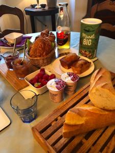 una mesa con pan y otros alimentos. en La Petite Jucherie, en Saint-Hippolyte