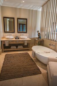 a bathroom with two sinks and a bath tub and a tub at Santé Wellness Retreat & Spa in Paarl