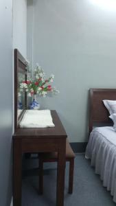 1 dormitorio con mesa, espejo y cama en Enjoy Mekong Hostel en Can Tho