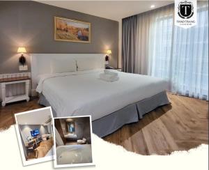 - une chambre avec un grand lit blanc et une fenêtre dans l'établissement Thao Trang Laluxe Hotel Phu My Hung, à Hô-Chi-Minh-Ville