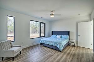 um quarto com uma cama, uma cadeira e janelas em Spacious and Modern Townhome 6 Mi to Duke! em Durham