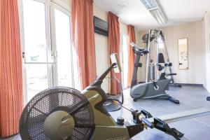 gimnasio con cinta de correr y bicicleta estática en una habitación en Maison résidence Odalys à Morgat en bretagne sur la presqu'île de crozon ,piscine chauffée, située à 800 m de la mer, en Crozon