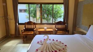 a hotel room with a bed with a swan on it at Thongplu Beach Resort Samui in Ban Thong Phlu