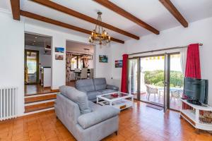 ein Wohnzimmer mit einem Sofa und einem TV in der Unterkunft Casa Honiol, private and spacious villa with sea views in Cala en Porter