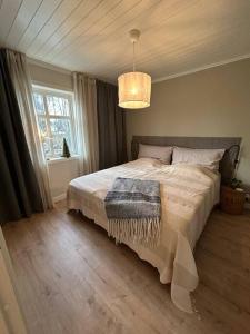 a bedroom with a large bed with a large window at Ny lägenhet i Vesene in Ljung