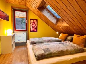 a bedroom with a bed and a wooden ceiling at Eifel-Ferienhaus Lavendel in Simmerath