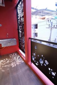 um quarto com paredes vermelhas e uma janela com piso em Room2u em Hat Yai