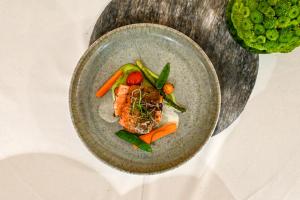 un plato de comida con carne y verduras en una mesa en Restaurant & Hotel Dabuki, en Neutal