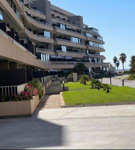 um grande edifício de apartamentos com um parque em frente em Atico Duplex en Playa Serena em Roquetas de Mar