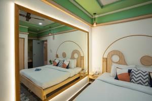 two beds in a room with two mirrors at Zostel Delhi in New Delhi
