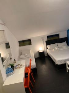 Cette petite chambre comprend deux lits, une table et des chaises. dans l'établissement Galaxy Pods @ Chinatown, à Singapour