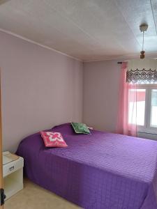 a purple bed in a bedroom with a window at Granny´s House Kuusela in Portimo