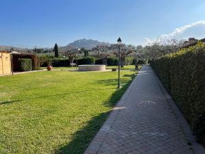 a walkway in a park next to a hedge at Valle del Metauro Country House in Montemaggiore al Metauro