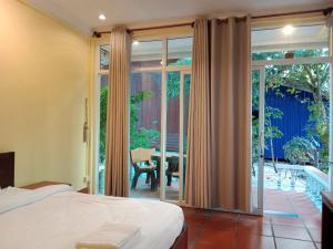 a bedroom with a bed and a sliding glass door at Sok San Villa Koh Rong in Phumĭ Kaôh Rŏng